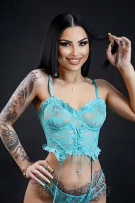 Smiling girl with black hair and tattoos